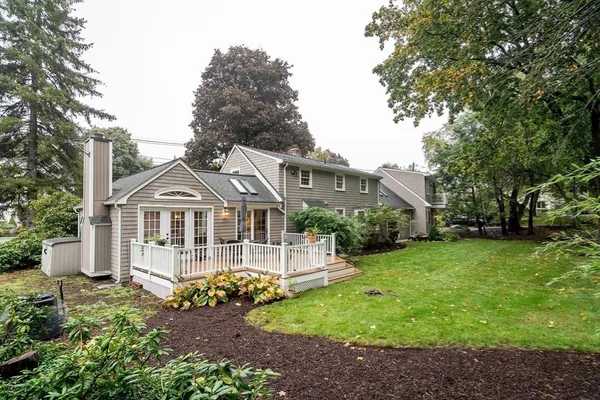 a front view of a house with a garden and trees