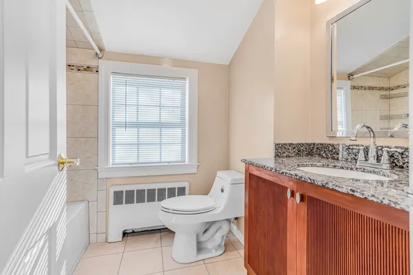 a bathroom with a granite countertop toilet a sink and a bathtub