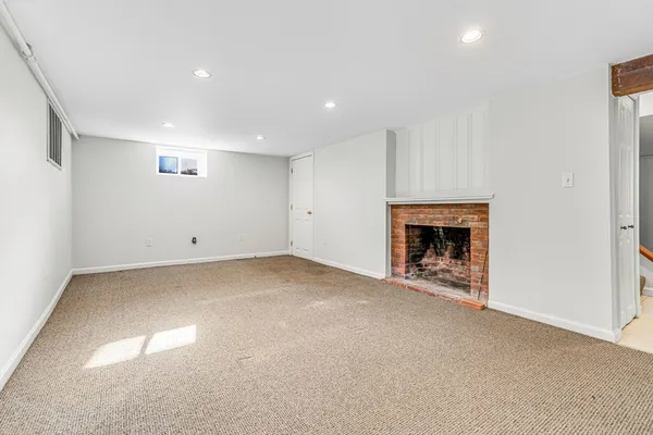 an empty room with fireplace and a window