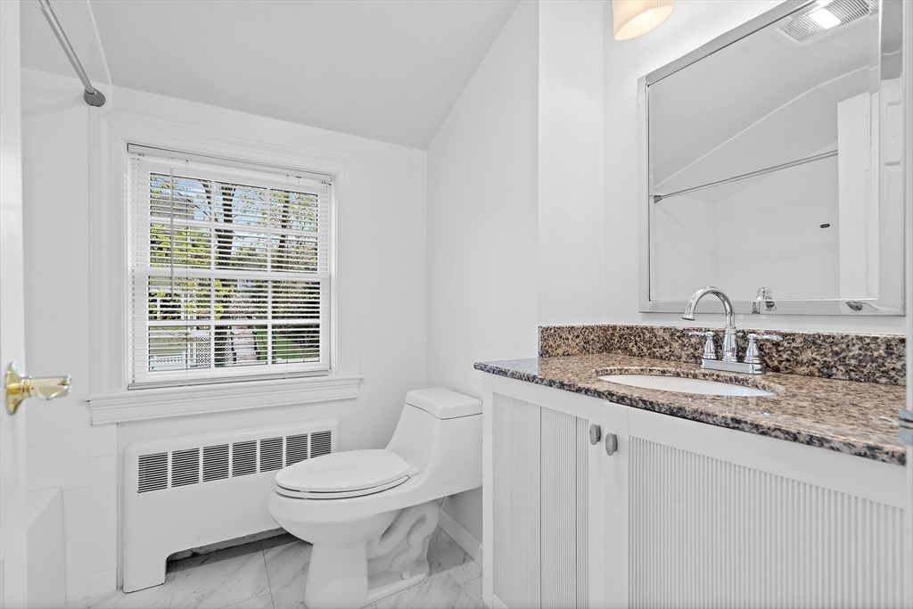 2270 Massachusetts Avenue Lexington, MA 02421 - Photo 25 of 33 a bathroom with a granite countertop sink a toilet and a mirror