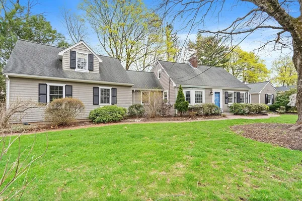 a view of a house with a yard and potted plants