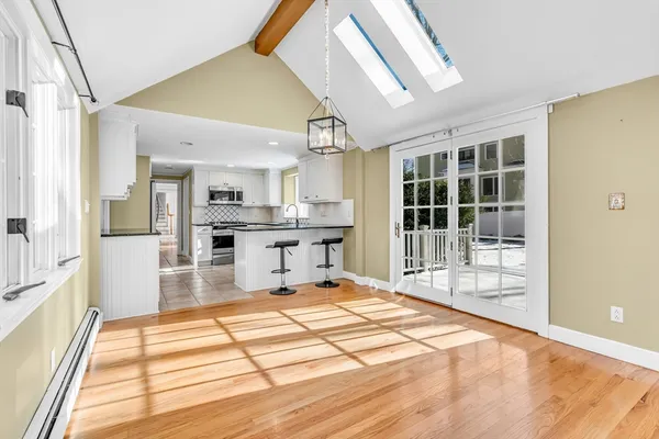 a large kitchen with kitchen island a large window and stainless steel appliances