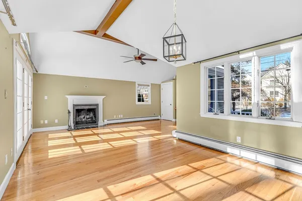 a view of an empty room with window and a fireplace