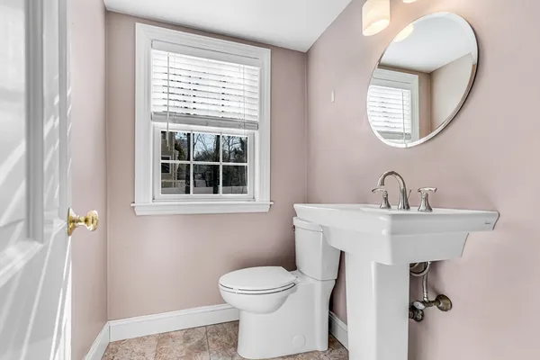 a bathroom with a toilet a sink and mirror
