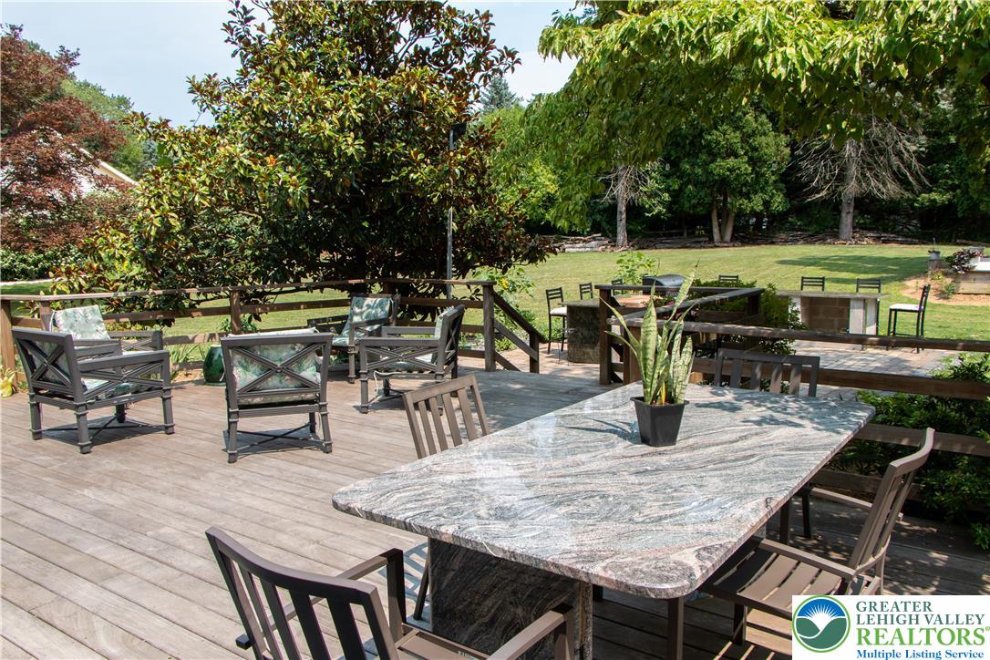 3582 Country Club Road Easton, PA 18045 - Photo 42 of 48 A spacious wooden deck provides ample outdoor living space, featuring a granite-topped dining table and comfortable seating.