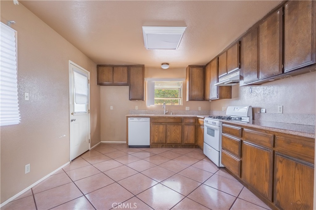 6084 Vanessa Street Riverside, CA 92504 - Photo 25 of 35 a kitchen with a sink a stove cabinets and a window