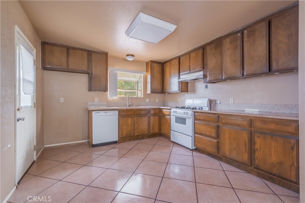 6084 Vanessa Street Riverside, CA 92504 - Photo 26 of 35 a kitchen with a stove sink and cabinets