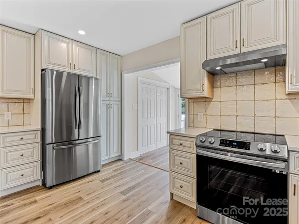 a kitchen with white cabinets and appliances
