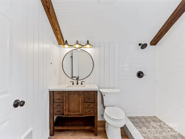 a bathroom with a sink a toilet a window and shower