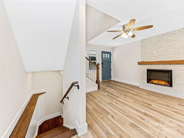 a view of a kitchen with a sink and dishwasher with wooden floor