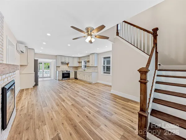 a view of a livingroom with wooden floor and a fireplace
