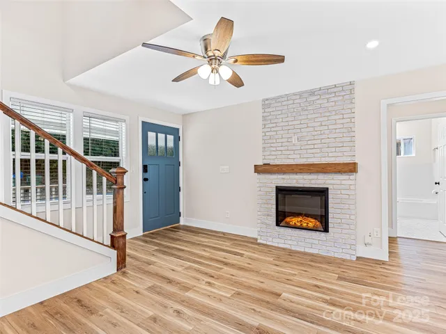 a kitchen with granite countertop a refrigerator oven a sink dishwasher and white cabinets with wooden floor