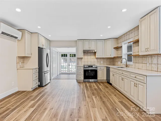 a kitchen with stainless steel appliances granite countertop a stove and white cabinets