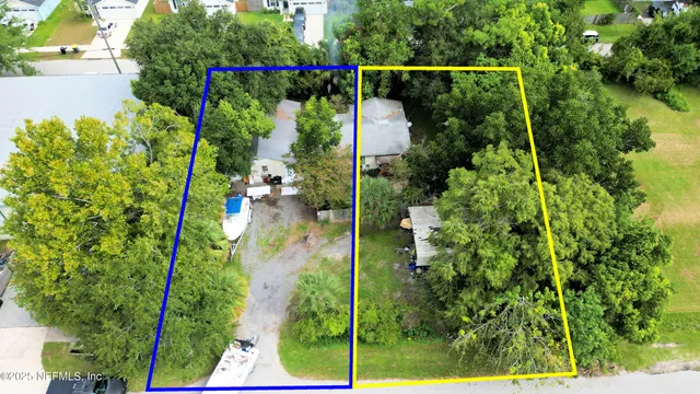an aerial view of a house with a yard and trees all around