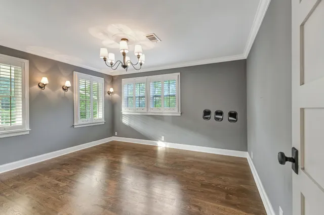a view of a hallway with wooden floor and chandelier