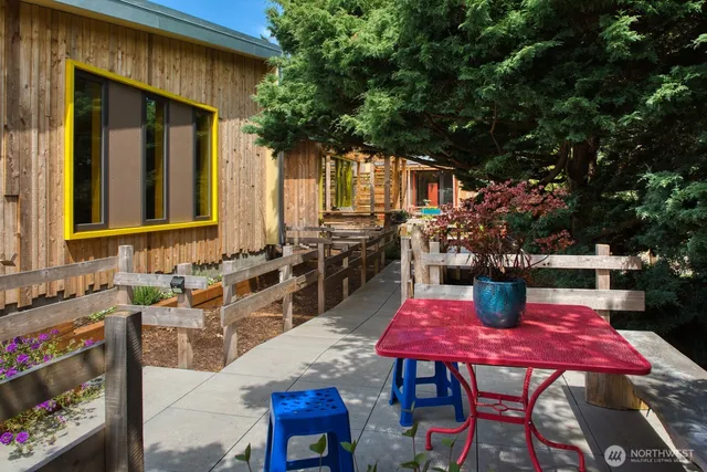 a view of a patio with table and chairs with wooden floor and fence