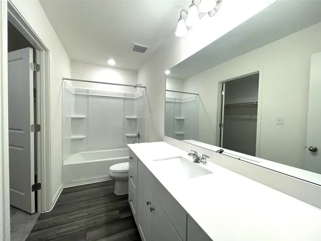 a bathroom with a double vanity sink toilet mirror and bathtub