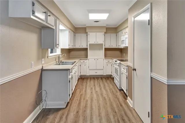 a kitchen with cabinets a sink and appliances