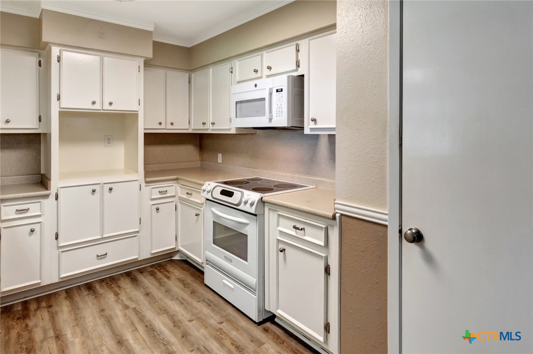 919 Eden Roc Street Victoria, TX 77904 - Photo 12 of 36 a kitchen with granite countertop a stove top oven sink and cabinets