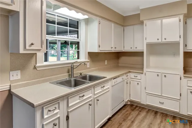 a kitchen with granite countertop white cabinets and white appliances