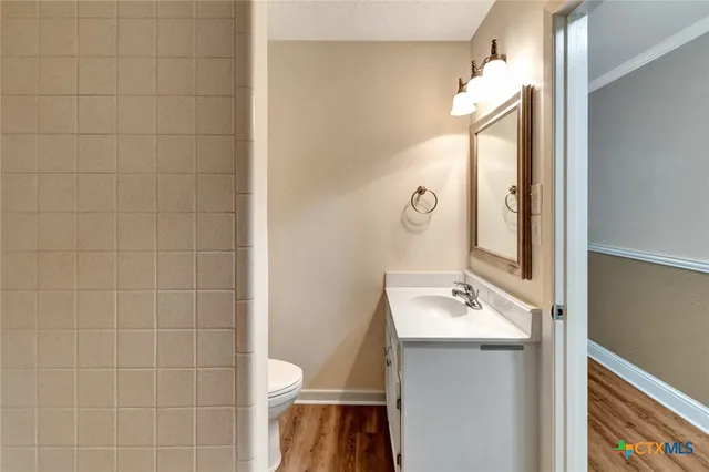 a bathroom with a sink a toilet a mirror and shower