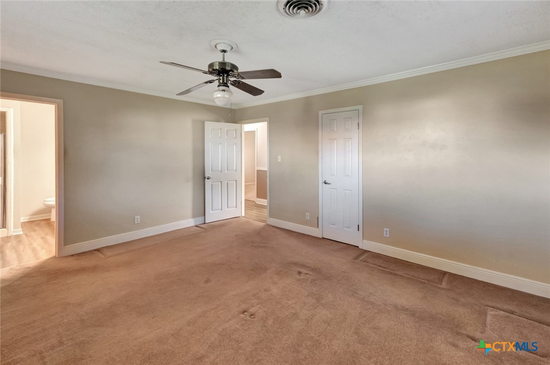 919 Eden Roc Street Victoria, TX 77904 - Photo 22 of 36 an empty room with a chandelier fan and windows