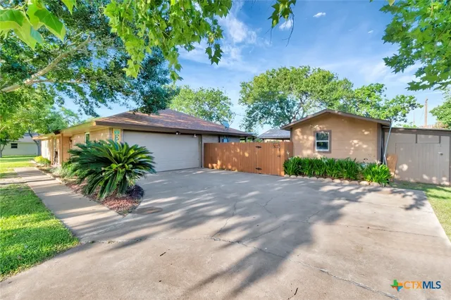 a view of a house with a yard and a garage