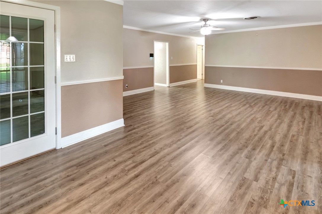 919 Eden Roc Street Victoria, TX 77904 - Photo 9 of 36 an empty room with wooden floor cabinet and windows