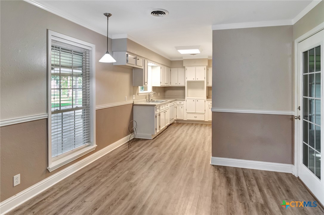919 Eden Roc Street Victoria, TX 77904 - Photo 10 of 36 a view of a kitchen with wooden floor and a window
