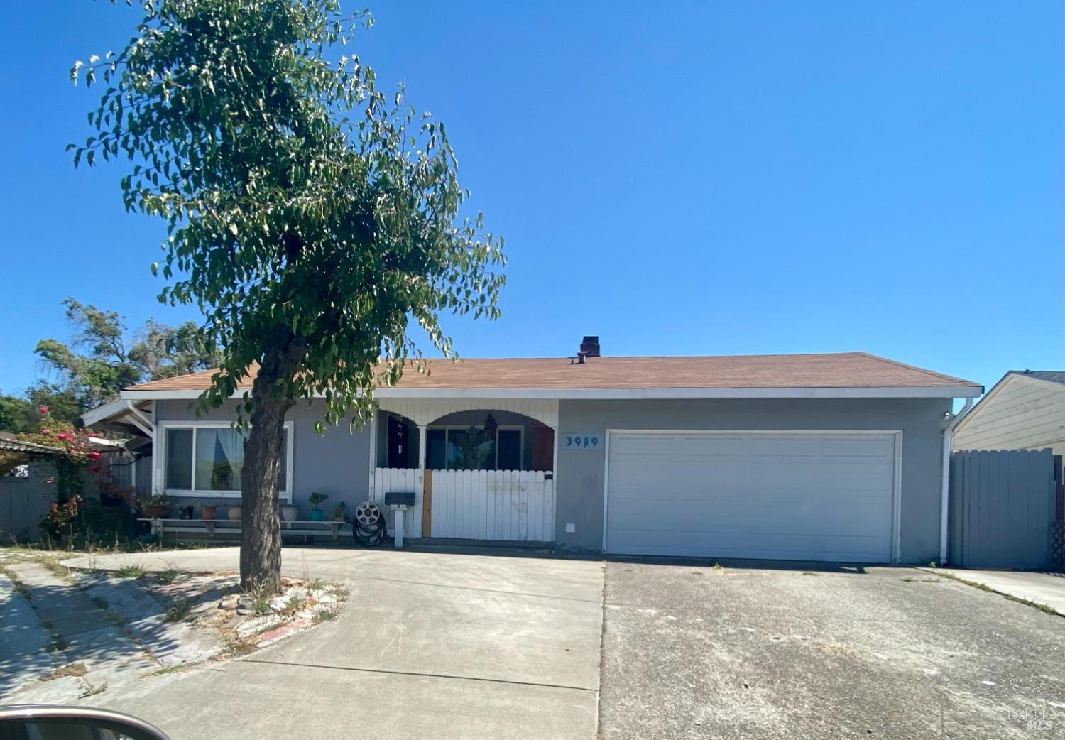 a front view of a house with a tree