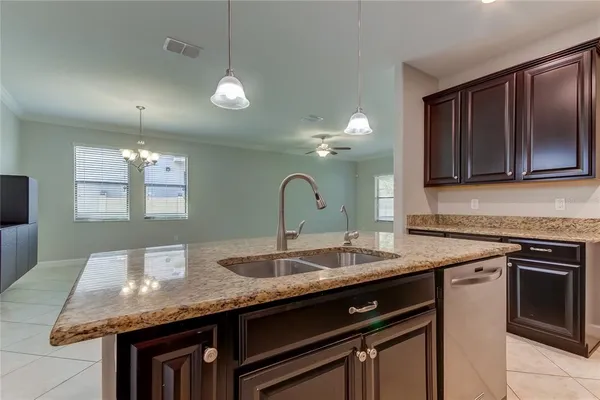 a kitchen with granite countertop kitchen island a sink stainless steel appliances and cabinets