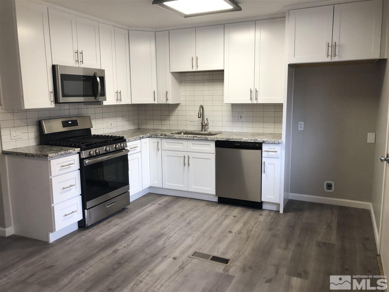 799 Lodge Avenue Reno, NV 89503 - Photo 2 of 6 a kitchen with granite countertop a stove top oven a sink dishwasher and a refrigerator with wooden floor