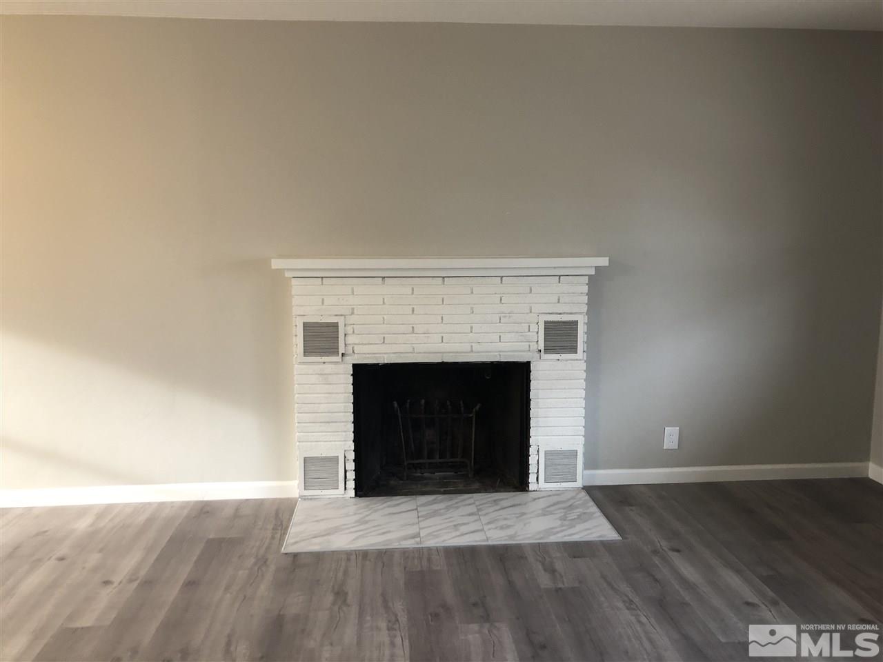 799 Lodge Avenue Reno, NV 89503 - Photo 4 of 6 an empty room with wooden floor and fireplace