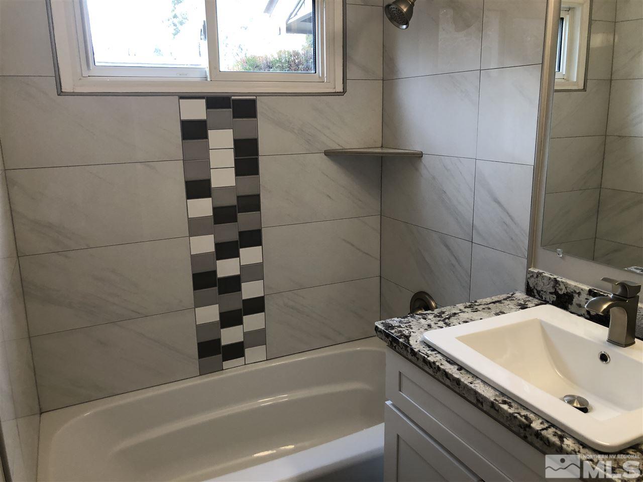 799 Lodge Avenue Reno, NV 89503 - Photo 6 of 6 a bathroom with a granite countertop sink a bathtub and window