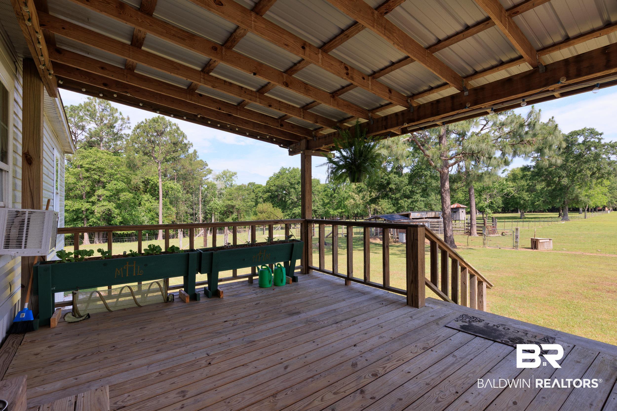 6725 Upper Creek Road Flomaton, AL 36441 - Photo 10 of 61 Deck featuring a yard, view of scattered trees, and cooling unit