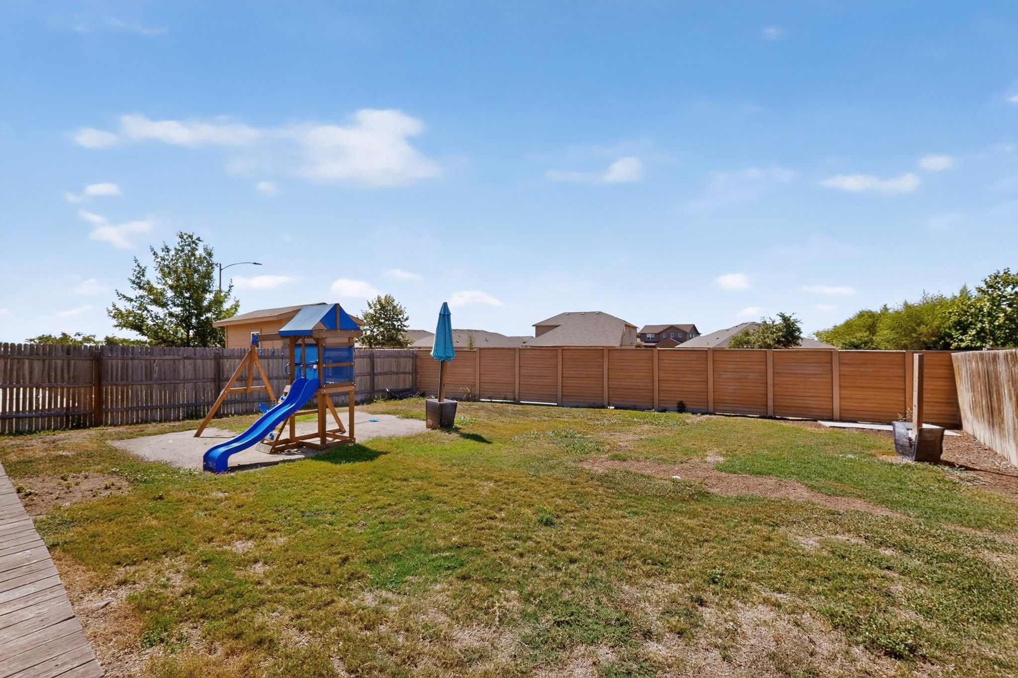 11612 Andesite Road Manor, TX 78653 - Photo 27 of 40 A spacious grassy lawn is fully enclosed by a sturdy wooden privacy fence.