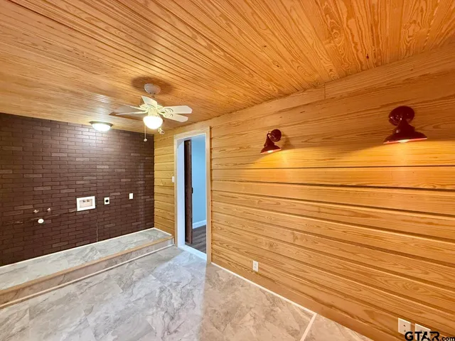 a bathroom with a granite countertop sink a toilet a mirror and bathtub