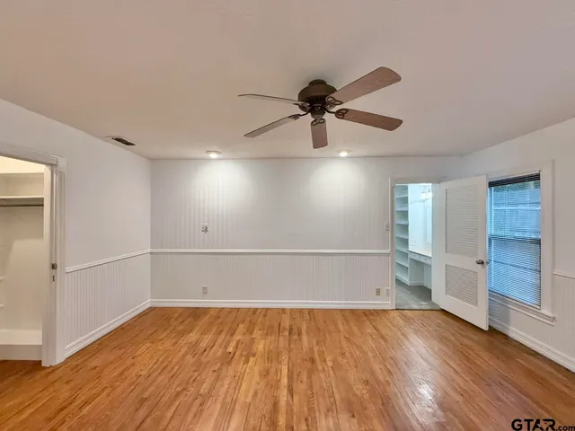 a view of empty room with wooden floor