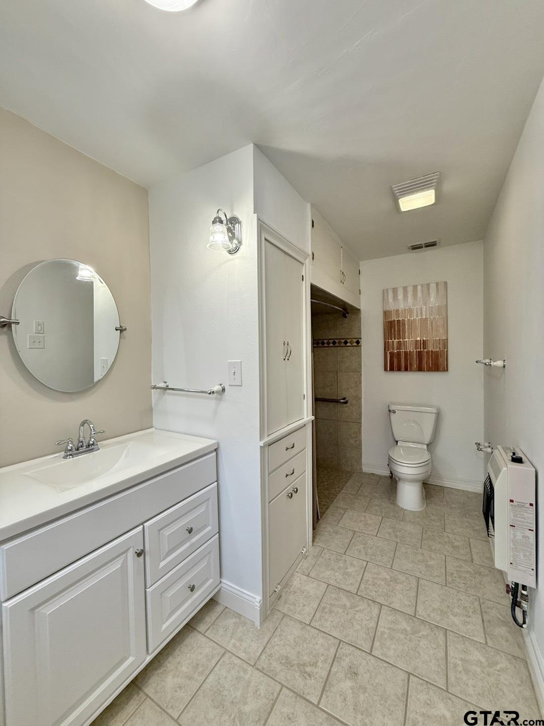 603 Wilma Street Tyler, TX 75701 - Photo 25 of 26 a spacious bathroom with a toilet sink and a mirror