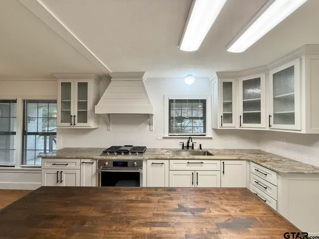 a kitchen with granite countertop a stove sink and cabinets