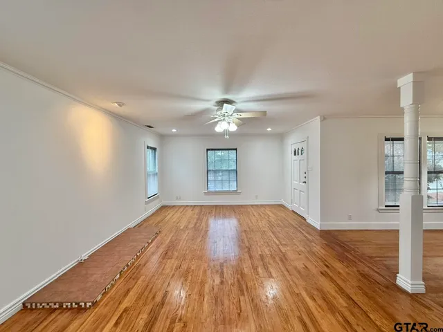 a view of empty room with wooden floor