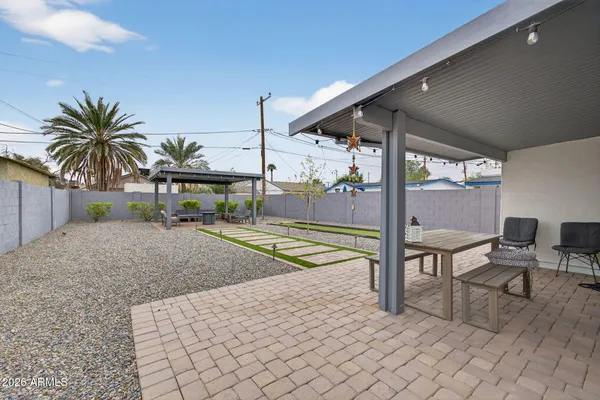 a living room with patio furniture and a potted plant