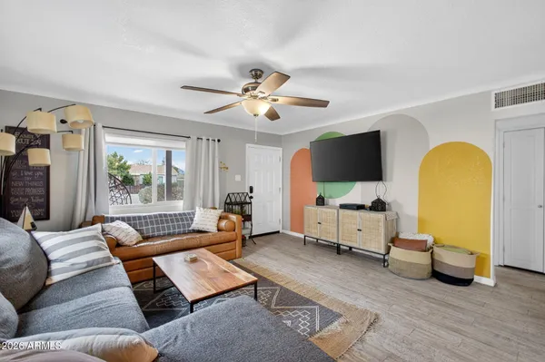 a kitchen with stainless steel appliances a refrigerator a stove a sink dishwasher and white cabinets with wooden floor