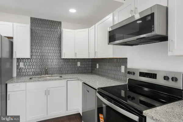 a kitchen with a sink stove and microwave
