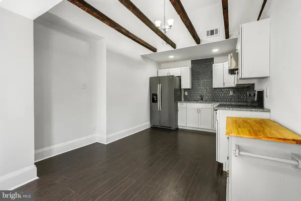 a view of a kitchen with a sink and dishwasher a refrigerator with wooden floor