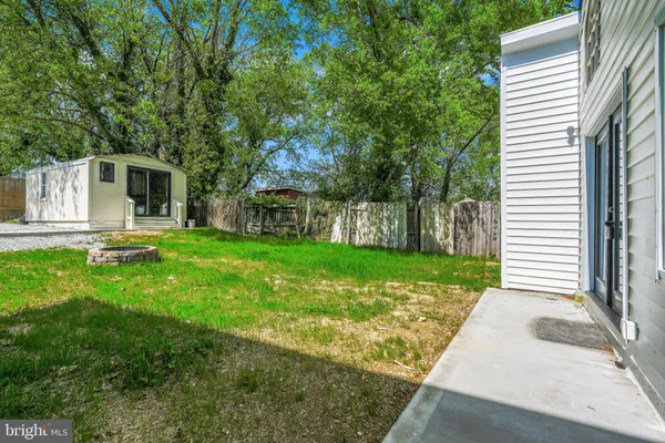 a view of a backyard with table and chairs and wooden fence
