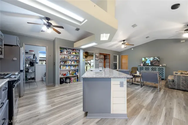 a kitchen with granite countertop a sink cabinets and wooden floor