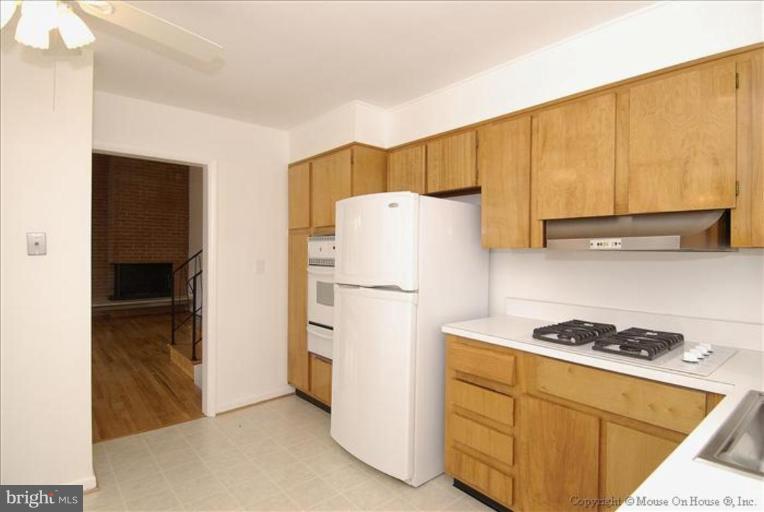 10114 Renfrew Road Silver Spring, MD 20901 - Photo 11 of 27 a white refrigerator freezer and a stove sitting inside of a kitchen