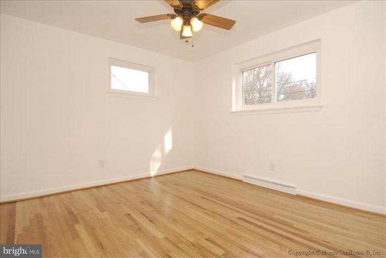 10114 Renfrew Road Silver Spring, MD 20901 - Photo 6 of 27 an empty room with wooden floor chandelier fan and windows