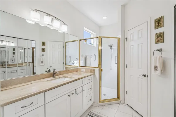 a spacious bathroom with a shower sink and mirror